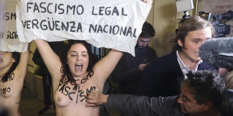 Un hombre toca los pechos de dos activistas de Femen que habían irrumpido en la entrada de la misa por Franco